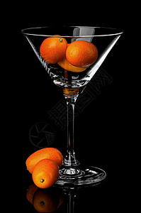 橙鸡尾酒金橘在马提尼玻璃杯中用黑色背景的马提尼玻璃里用柠檬库姆夸特反倒面用马蒂尼玻璃里Ripekumquat图片