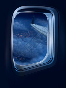 客机夜间飞行由位于照亮城市上空高处的喷气式飞机窗口观夜行空气旅图片