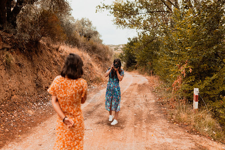 太阳探索女两名年轻子在森林附近的一条路上拍照图片