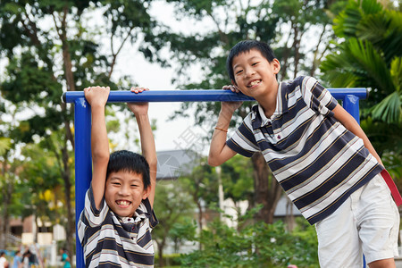 快乐的孩子们双兄弟在游乐场玩耍和嘲笑图片