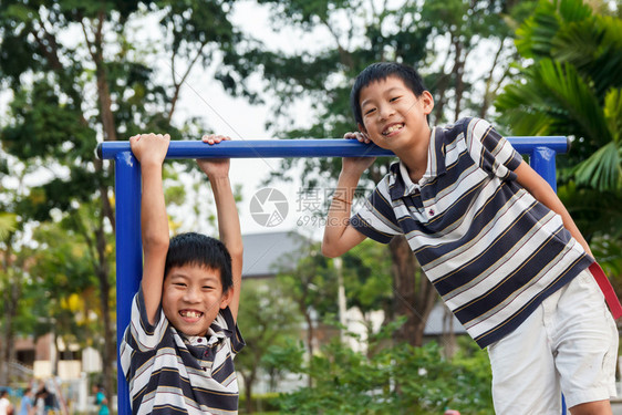 快乐的孩子们双兄弟在游乐场玩耍和嘲笑图片