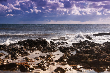 冲浪场景风暴海中沉积的岩石海岸云和雨图片