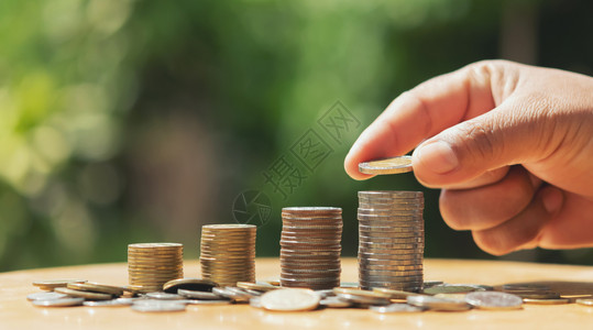 推杆经济将硬币和阳光概念金融与会计放在桌边的纸币上以节省钱手储蓄环境图片