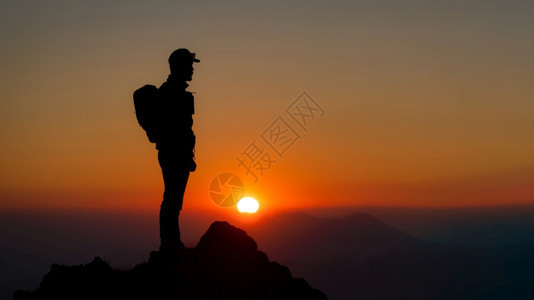 冒险在山顶登的者看着美丽的夕阳在月光下背包荒野图片