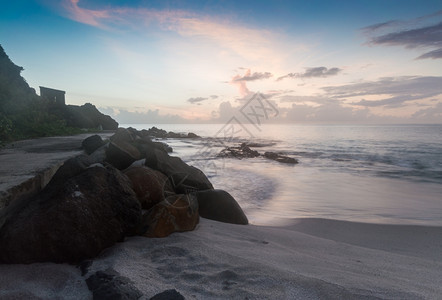 海洋紫红色岩石圣卢西亚海滩边缘的日落圣露西亚图片