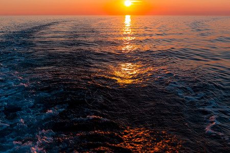 一种海中日落和船只的踪迹自然痕图片