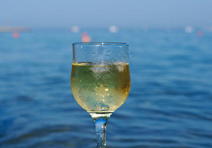 放松饮料晴天海浪冲刷的岩石边杯白葡萄酒被海浪冲洗过图片