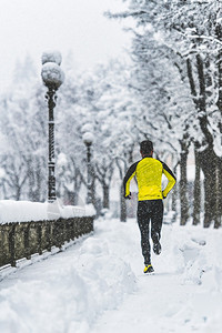 年轻人在冬天的雪地上奔跑图片