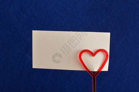 空的象征情人节一张红色心胸的纸条持有者上面一张在蓝色背景下被孤立的纸条图片