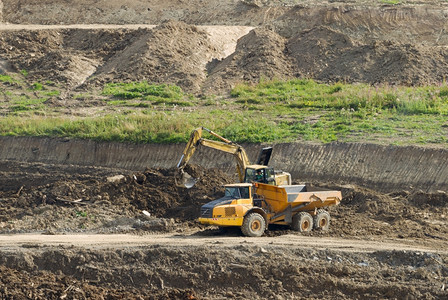 矿行业景观在采石场工作的卡车和挖土图片