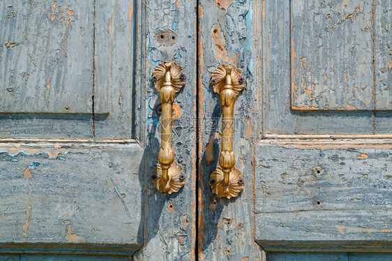 古旧老的董门把手在旧蓝色木制门上乡村私人的保护图片