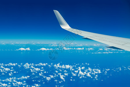 飞越蓝天和白云空的飞机翼在行时透过机窗仰望可视空间商业的美丽看图片