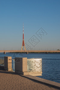城市观看位于RIga的DaugavaPromenade在阳光明媚的春夜阳光和闪亮的水从玻璃阳台反射到南部水桥和Riga无线电台和图片