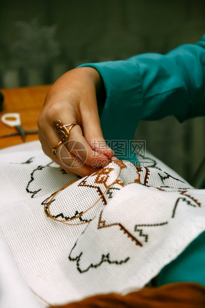 女士工艺爱好近女手亲在棉布上交叉切开手工制作的刺绣图片