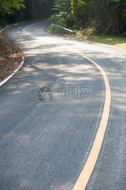 沿着山坡的弯曲道路从山上向下弯来公路两侧还有更多的树林车转动木图片