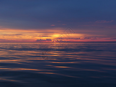 旅行景区海面的黄昏暮光下赤红日落海浪图片
