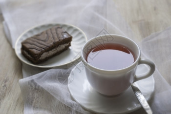 餐巾杯子在桌上蛋糕子与一杯茶和蛋糕起站在桌上厨师盘子图片