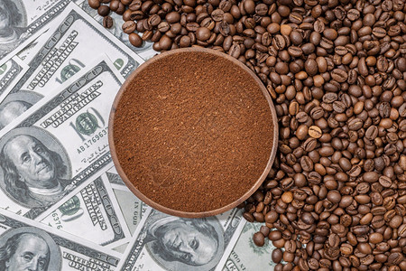 现金经济在咖啡豆和美元钞票上隔绝的木板制咖啡地面以豆和纸钞为隔离贸易背景图片