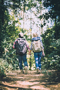 活动途径年轻夫妇在森林冒险远足时带着背包散步一起享受节假日夏天图片