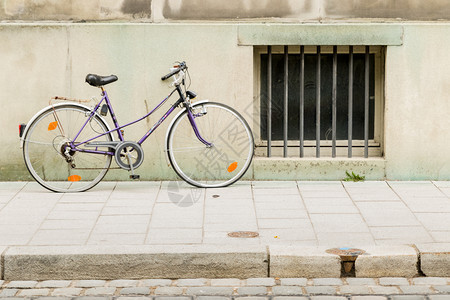 城市的街道运输一辆旧自行车靠在城市建筑的墙壁上图片
