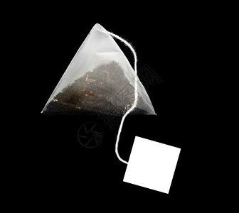 茶包饮料在黑暗背景中被孤立的金字塔形茶袋图片