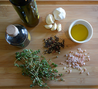 胡椒百里香一份拉面盘上的橄榄油一瓶巴萨醋大蒜百香粉红盐和木切板上的胡萝卜木头图片