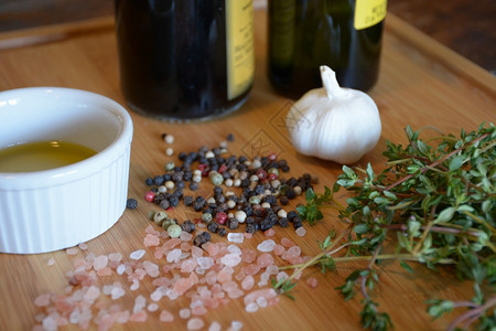 一份拉面盘上的橄榄油一瓶巴萨醋大蒜百香粉红盐和木切板上的胡萝卜椒粒切割烹饪图片