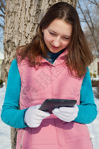 阅读冬天在公园里看电子书的青少年女孩一种松弛图片