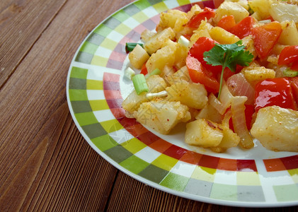 煮熟的立方体红色OrsqioBrien番薯土豆盘以及绿色和红铃椒图片