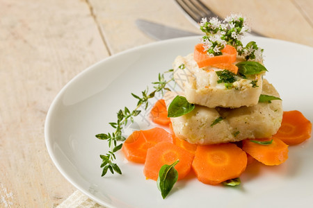 可口地中海以新鲜红菜和巴西尔为生的胡萝卜上美味鳕鱼的照片新鲜图片