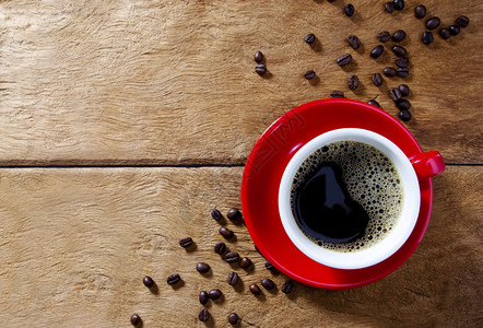 蒸汽黑板豆子红咖啡杯放在木桌上有咖啡珠和豆背景图片