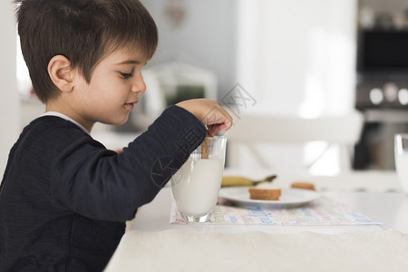 前视图孩子蘸饼干牛奶坚果业务图片