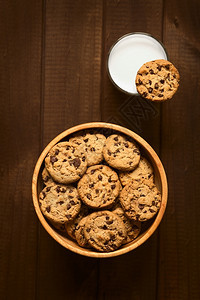 木碗中巧克力曲奇饼和一杯冷牛奶边上块饼干用天然光照在木头上的片拍摄到面条上甜点喝乡村图片