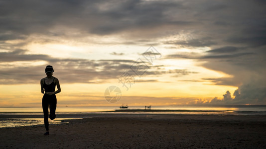 妇女早上在海滩慢跑时穿运动服户外白种人女士图片