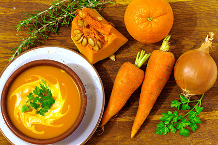 南瓜橙子和胡萝卜汤秋天木制的健康图片