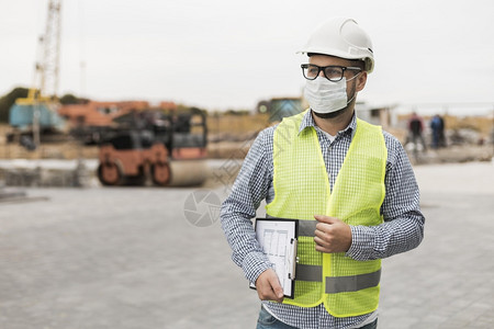 安全的高身戴面具中建筑工男子蔬菜图片