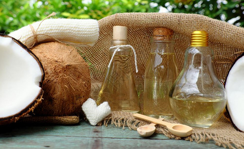 本质天然化妆品产绿底玻璃罐中的椰子油用于皮肤护理的必要油丰富维他命有机化妆品以及温泉按摩机的油治疗液体图片