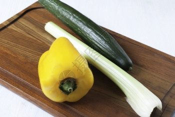 营养厨房切割板上的黄胡椒大菜和瓜脆的木板图片