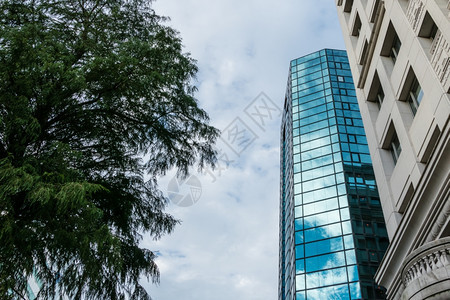 城市现代玻璃建筑在旧式旁边反射云和天空办公室正面图片