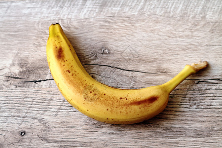 饮食异国情调浅木桌上的黄香蕉浅木桌上的黄香蕉生图片