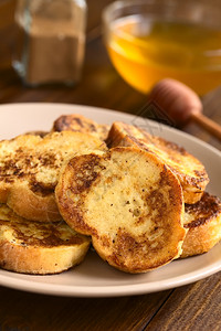 法式吐司由背面的包蜂蜜和肉桂粉制成用自然光拍攝选择焦点关注立方烤面包的上半部分自制背一顿饭图片