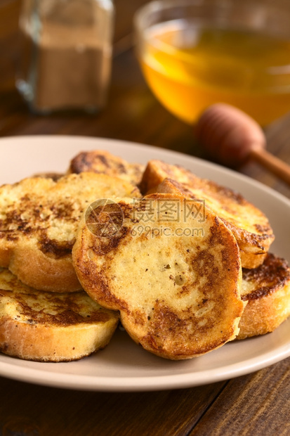 法式吐司由背面的包蜂蜜和肉桂粉制成用自然光拍攝选择焦点关注立方烤面包的上半部分自制背一顿饭图片