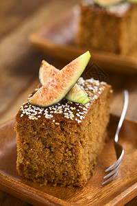 重点小吃棕色的新鲜无花果蛋糕上面有无花果插头在木板上摆放有糕饼