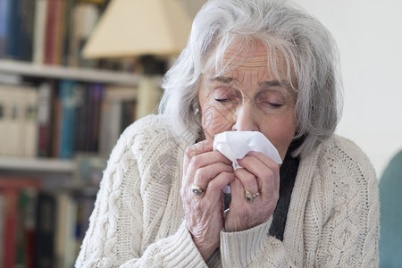 家里吹流感鼻子的年长妇女白种人伤心传染图片