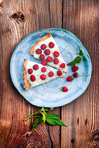 家蛋糕上面的旧木制桌子上蓝色手工制陶瓷板上的布丁和新鲜草莓水果美味的盘子图片