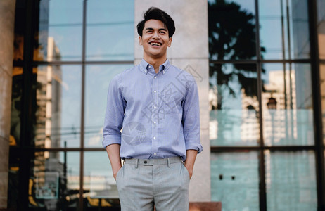 随意的愉快城市中微笑的年轻亚洲商人肖像一个快乐的友善人模型图片