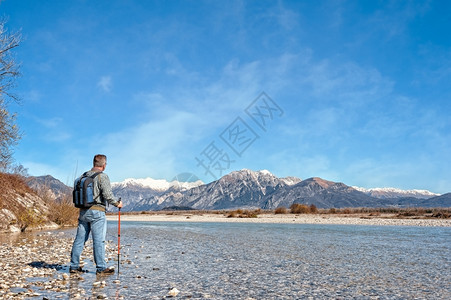 朝向在一条河流的岸上登山者向朗布勒走去大约60岁现职退休空间徒步旅行男图片