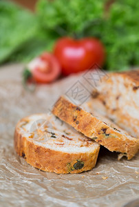 健康烘烤的桌子白切片自制袋式面包饼含干西红柿和草药图片