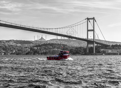 水伊斯坦布尔博普鲁海峡大桥下的土耳其船伊斯坦布尔博普鲁海峡大桥下的复古风格土耳其船复古风格地标运输图片