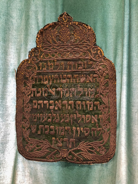 卡萨布兰正面用希伯来语的金盾牌保护犹太教堂里托拉卷轴在绿窗帘前安放盘子图片
